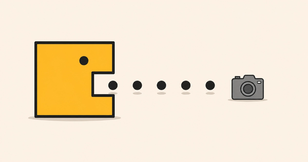 A yellow square character with a square notch for a mouth advancing along a row of pellets towards a plain grey camera icon.